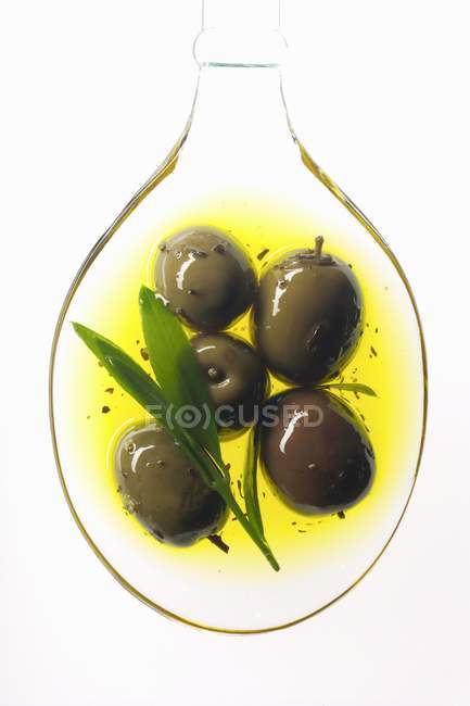 Olives in spoonful of oil — Stock Photo
