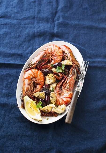 King Prawns with artichokes and olives — Stock Photo