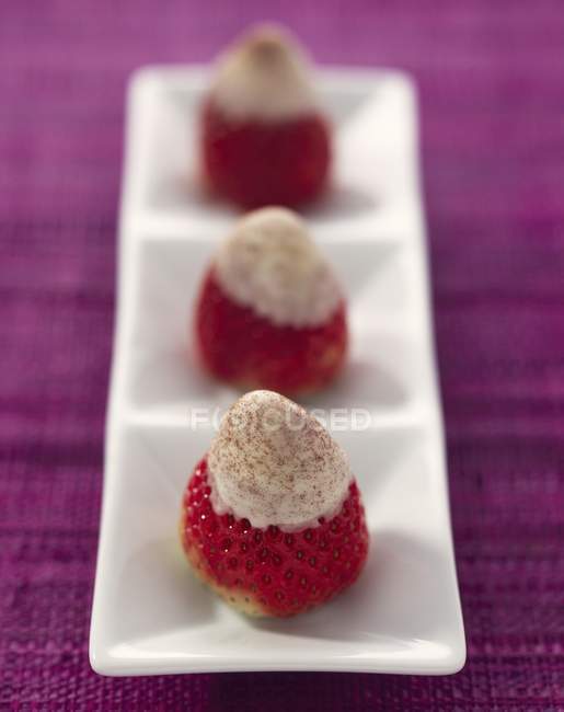 Closeup view of strawberries topped with white chocolate and bitter cocoa — Stock Photo