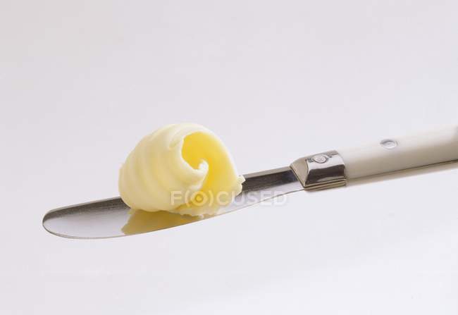 Rizo de mantequilla en el cuchillo - foto de stock
