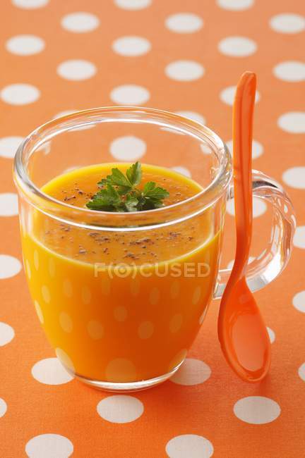 Zuppa di carote in tazza di vetro con cucchiaio — Foto stock