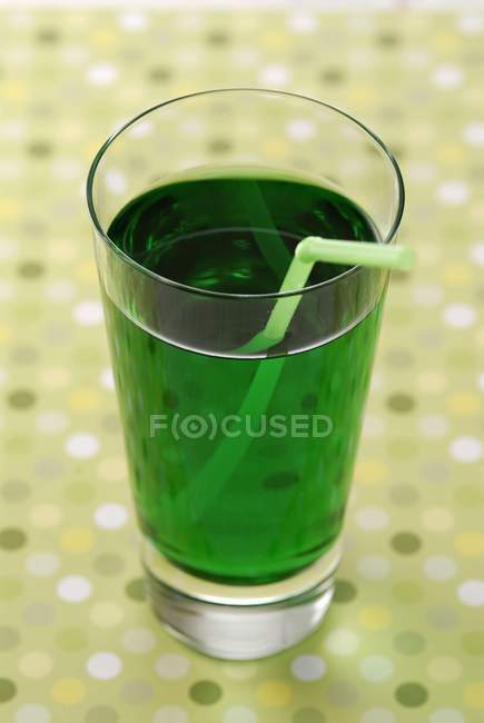 Closeup view of mint syrup with straw in glass — Stock Photo