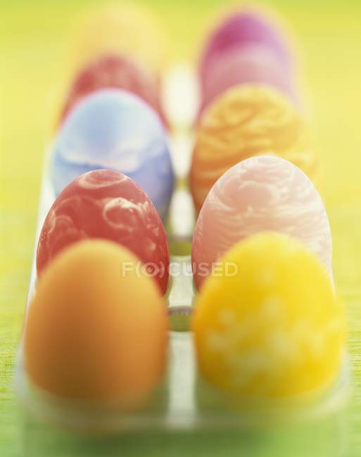 Vista close-up de linhas de ovos pintados em uma caixa de ovo — Fotografia de Stock