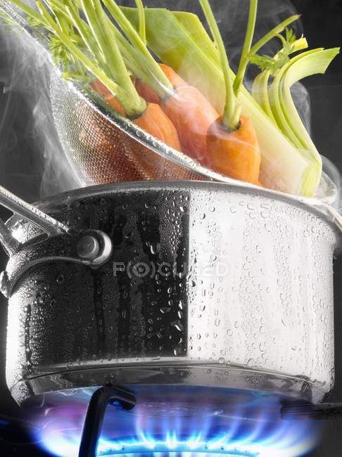Steam cooking carrots — Stock Photo
