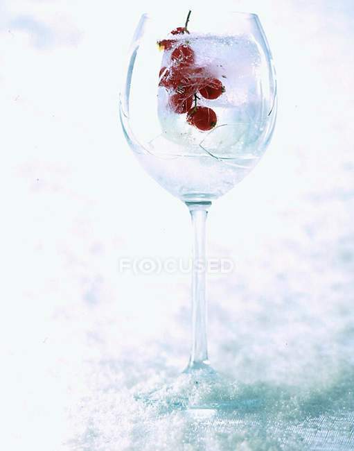 Vista de primer plano de agua helada con grosellas rojas en vidrio - foto de stock