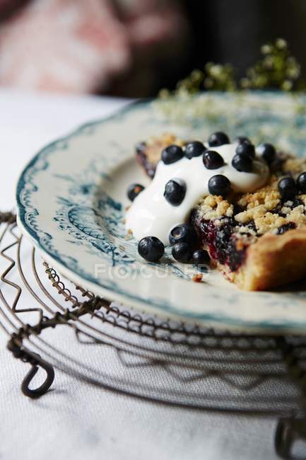 Piece of blueberry pie with cream — Stock Photo