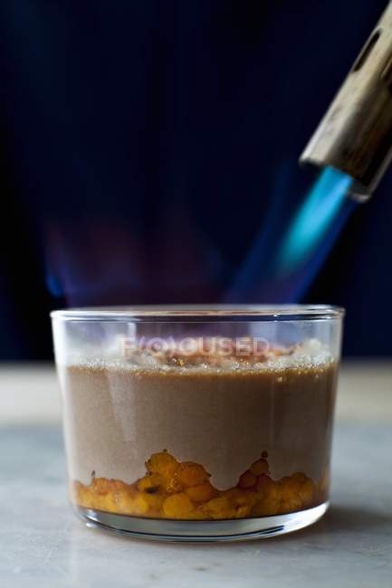 Closeup view of chocolate cream with cloudberries being caramelised — Stock Photo