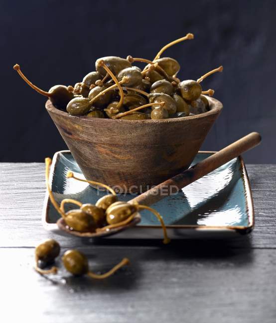 Giant capers in wooden bowl — Stock Photo