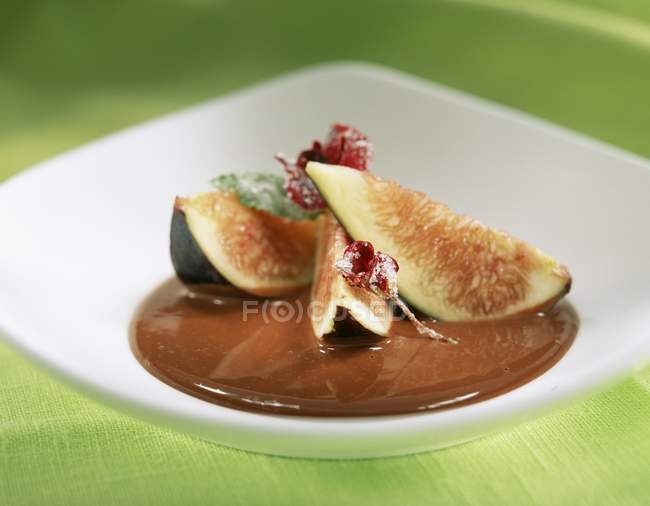 Closeup view of fig wedges with chocolate sauce on plate — Stock Photo