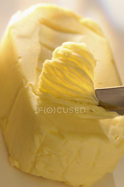 Knife scraping butter — Stock Photo
