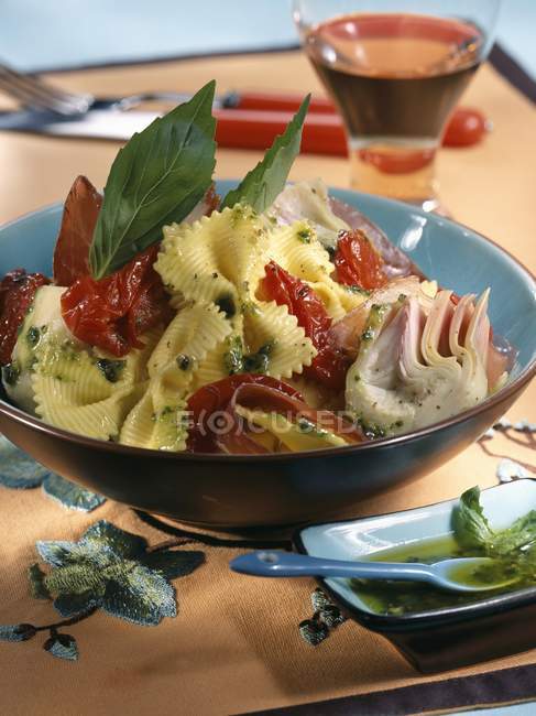 Ensalada de pasta Farfalle con tomates y jamón - foto de stock