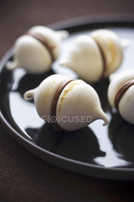 Chocolate meringues on dark plate — Stock Photo
