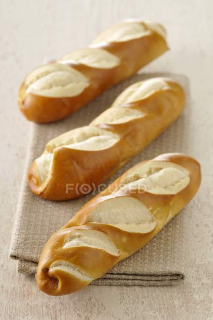 Closeup view of three baguette-shaped Bretzels — Stock Photo