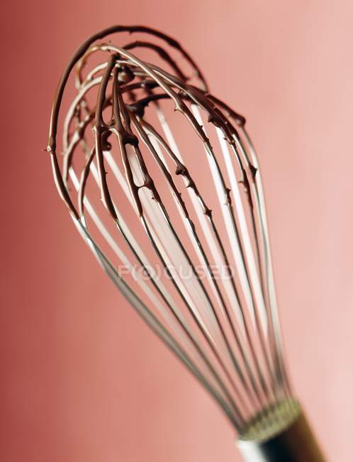 Whisk with melted chocolate — Stock Photo