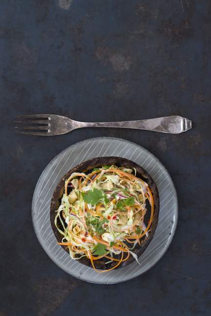 Fungo di Portobello farcito con insalata sul piatto su superficie scura con forchetta — Foto stock