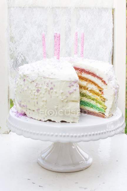 Pastel de arco iris con velas - foto de stock