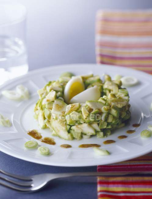 Avocado and courgette tartare on white plate — Stock Photo