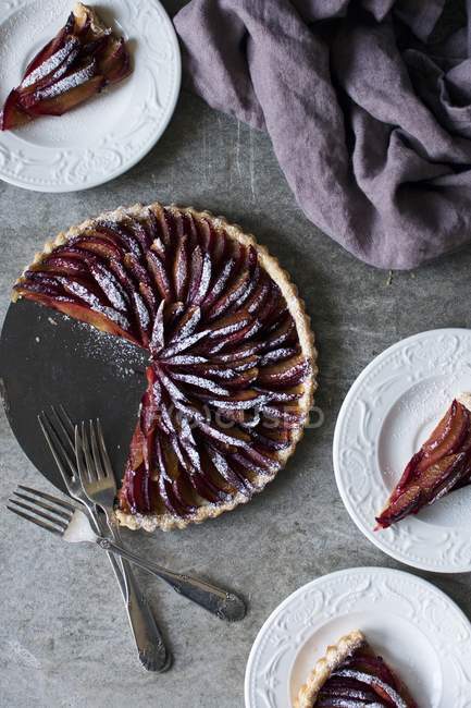 Plum tart dusted in icing sugar — Stock Photo