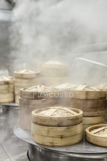 Cestas de vapor de bambu em uma cozinha fumegante — Fotografia de Stock