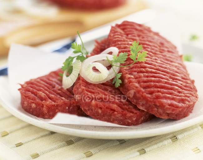 Hamburguesas de carne sin cocer - foto de stock