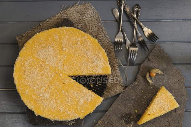 Lemon cheesecake with slice cut out — Stock Photo