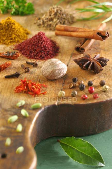 Assorted spices scattered on wooden desk — Stock Photo