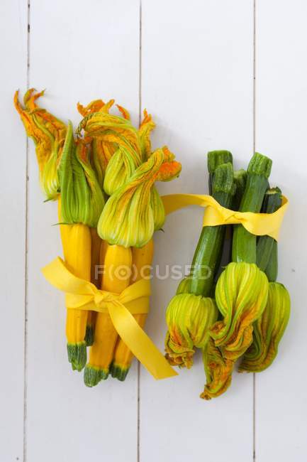 Courgettes jaunes et vertes aux fleurs — Photo de stock