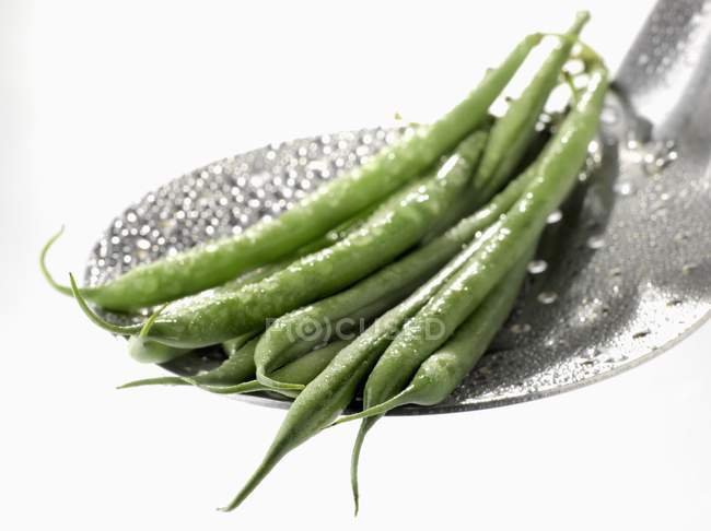 Green beans on skimmer — Stock Photo