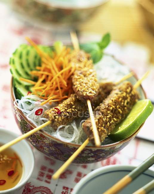 Meat and sesame seeds kebabs with noodles — Stock Photo