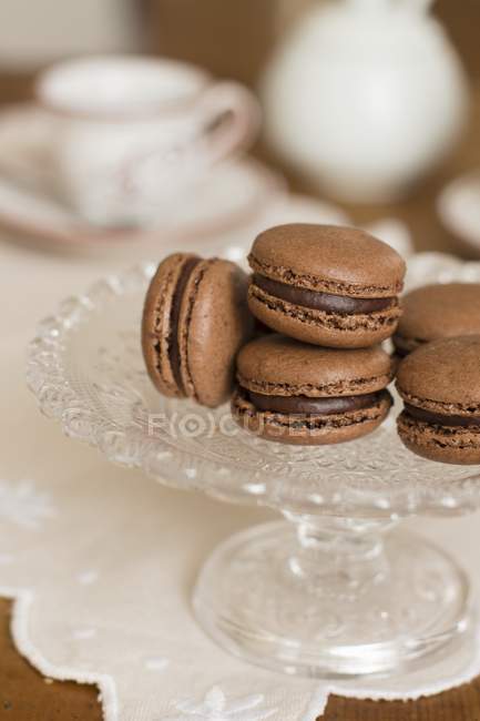 Closeup view of cocoa macarons on glass cake stand — Stock Photo