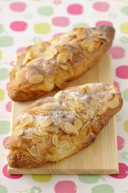 Almond croissants on wooden board — Stock Photo