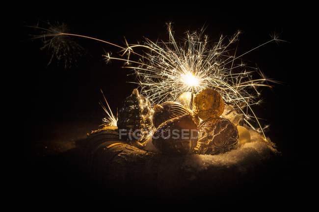 Closeup view of antique Christmas decorations and a sparkler — Stock Photo