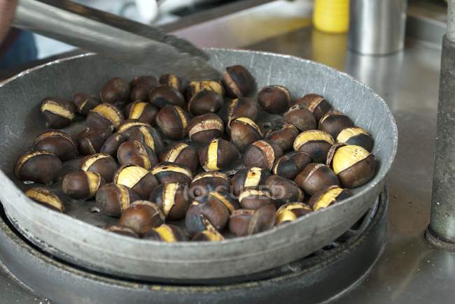Street vendor roasting chestnuts — Stock Photo