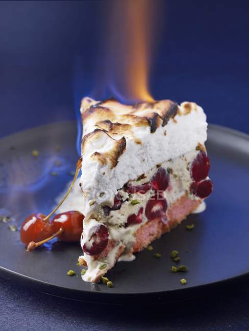 Vista close-up de queimar bolo cozido no Alasca com cerejas — Fotografia de Stock