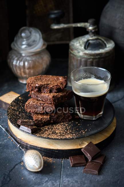 Fresh baked brownies with glass of coffee — Stock Photo