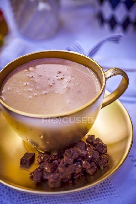 Chocolate caliente en taza de oro - foto de stock