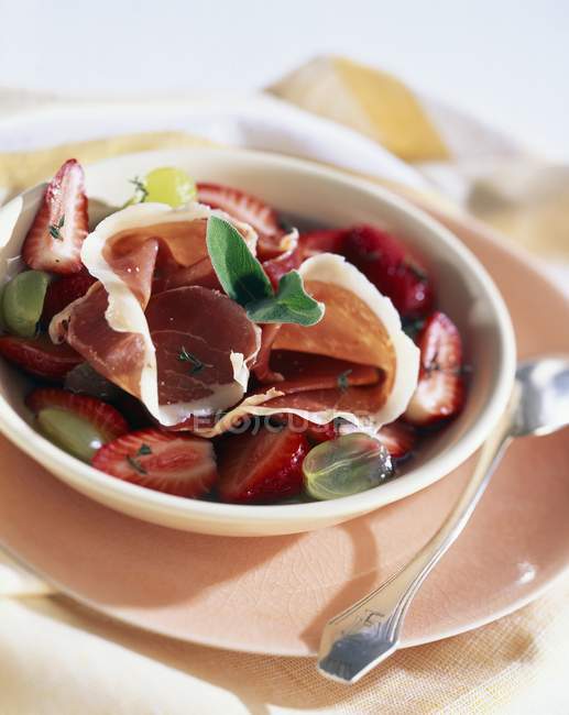 Smoked ham and strawberry salad in bowl — Stock Photo