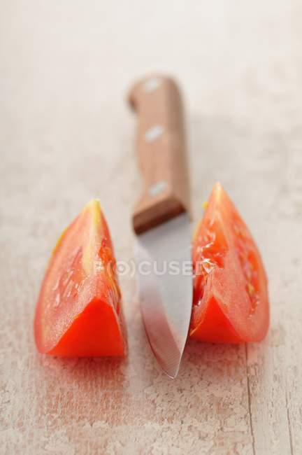 Tomate y cuchillo en rodajas - foto de stock