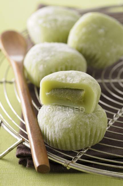 Green tea Mochis on wire rack with wooden spoon — Stock Photo