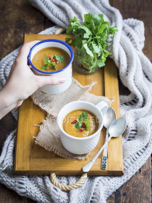 Веганський овочевий вершковий суп у двох чашках на дерев'яному фоні . — стокове фото