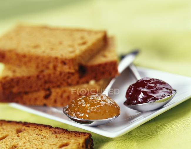 Gingerbread with jam on spoons — Stock Photo