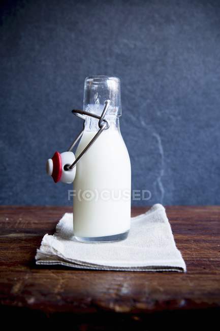 Botella de leche en la mesa - foto de stock