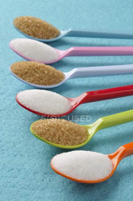 Colheres com açúcar branco e mascavo — Fotografia de Stock