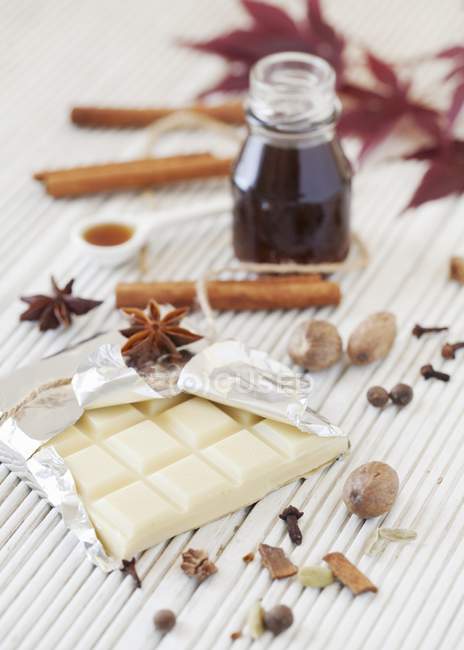 Disposición de chocolate blanco con especias y jarabe - foto de stock