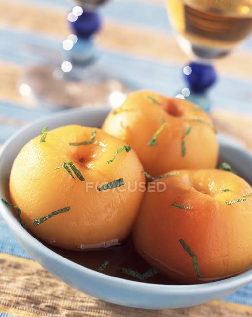 Closeup view of yellow peaches with wine and herb — Stock Photo