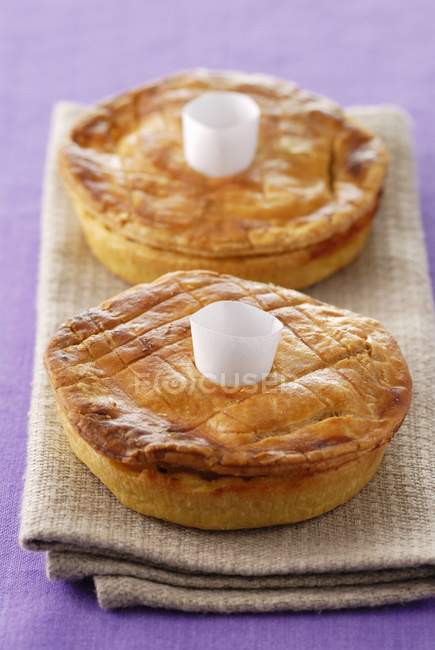 Potato pies laying on textile towel over purple surface — Stock Photo