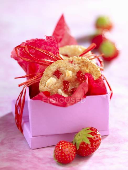 Chocolate branco e biscoitos de morango em caixa roxa sobre mesa — Fotografia de Stock