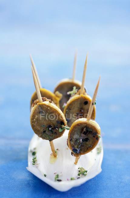 Closeup view of limpet skewers with thyme flowers — Stock Photo