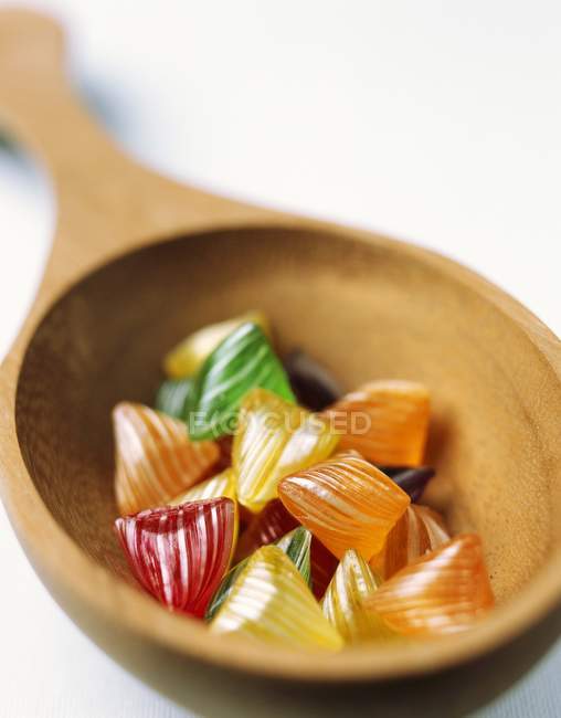 Closeup view of Berlingot boiled candies in wooden spoon — Stock Photo
