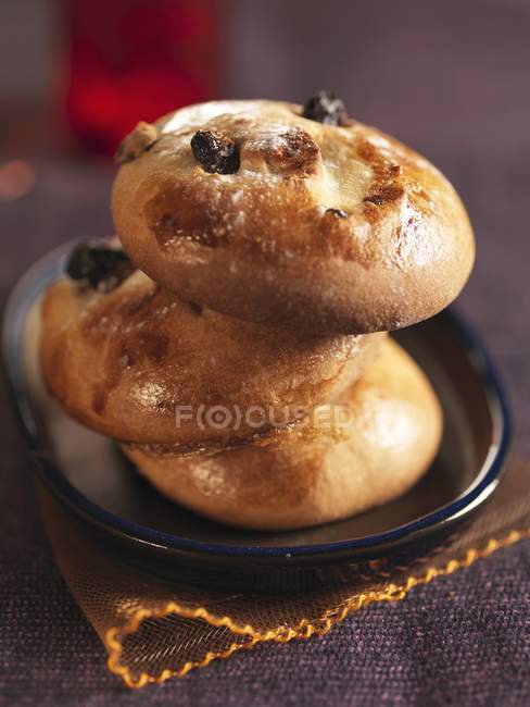 Vue rapprochée des petits pains empilés avec des raisins secs sur la plaque — Photo de stock